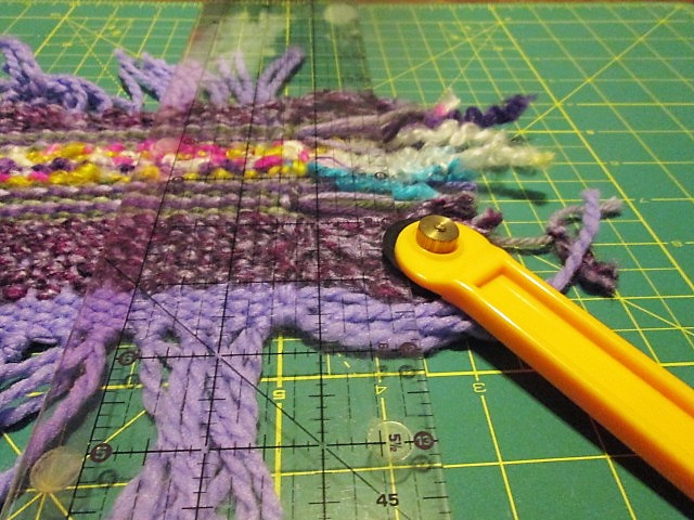 using a rotary cutter and ruler to trim threads in weaving