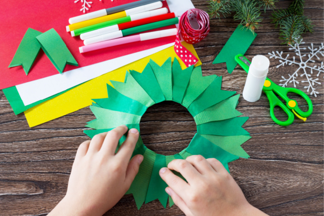 overlapping green paper strips as glued onto paper plate shaped like wreath