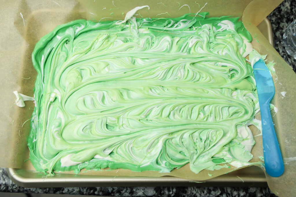 adding melted green candy melts to the white and swirling